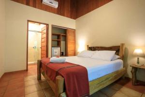 a bedroom with a bed and a dresser at Hotel Casa Merlin in Puerto Viejo