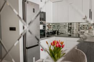 una cocina con armarios blancos y una mesa con flores en Apartament Villa Klar, en Ostróda