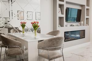 a dining room with a white table and chairs at Apartament Villa Klar in Ostróda