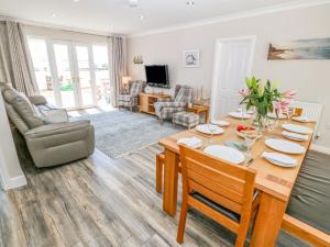 een eetkamer met een tafel en een woonkamer bij St Winifreds in Rhosneigr