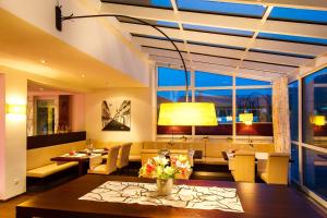 a dining room with a table and a large window at Hotel-Restaurant Bellevue in Ruhpolding