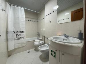 a white bathroom with a sink and a toilet at Praia Mar in Monte Gordo +33 photos