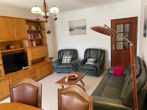 a living room with couches and a flat screen tv at Praia Mar in Monte Gordo