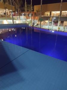 una gran piscina por la noche con piscina en Enjoy Solar das Águas Park Resort, en Olímpia