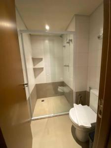 a bathroom with a toilet and a glass shower at Apartamento Resort Aguas Park Resort Olímpia in Olímpia