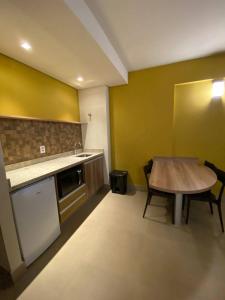 a small kitchen with a wooden table and a sink at Apartamento Resort Aguas Park Resort Olímpia in Olímpia