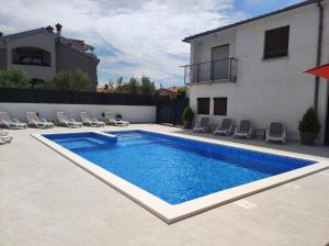 a swimming pool in front of a house at Viktor rooms and apartments in Rovinj