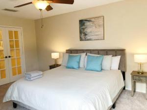 a bedroom with a large white bed with blue pillows at Entire 3 Bedroom Home Near Downtown King bed in Houston