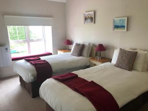 a hotel room with two beds and a window at Gortamullen House, Kenmare in Kenmare