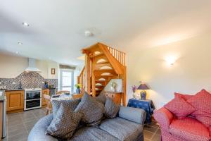 a living room with a couch and a kitchen at Cwmdu Cottage in Cwm-coy