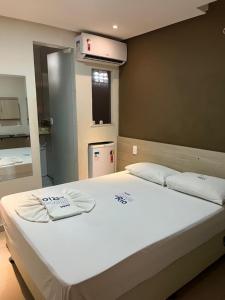 a bedroom with a large bed with towels on it at Boca do Rio Hotel in Salvador +23 photos