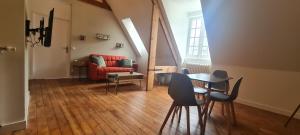 ein Wohnzimmer mit Tisch und Stühlen und einer Couch in der Unterkunft Le Rivoli - T3 - dernier étage in Pontivy + 7 Fotos