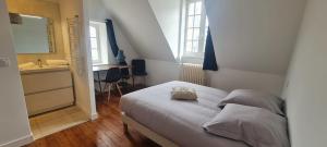 ein kleines Schlafzimmer mit einem Bett und einem Waschbecken in der Unterkunft Le Rivoli - T3 - dernier étage in Pontivy