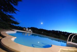 a swimming pool at night with the moon in the sky at Vandenbeld Wines B&B in Minzac