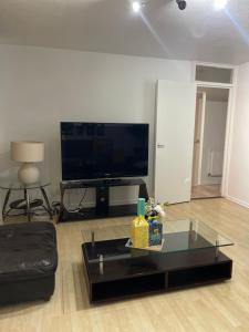 a living room with a tv and a coffee table at NewSuites in London