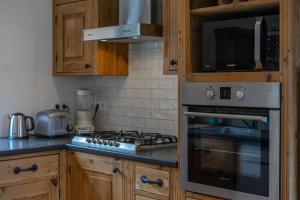 cocina con armarios de madera y horno con fogones en Charming Chalet With Garden In Les Houches, en Les Houches