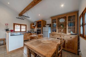 cocina con mesa de madera y nevera blanca en Charming Chalet With Garden In Les Houches, en Les Houches