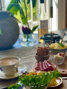 un tavolo con piatti e una tazza di caffè di Villa Utsikten a Tofte