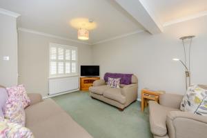 a living room with a couch and a chair and a tv at Rye House in Rye