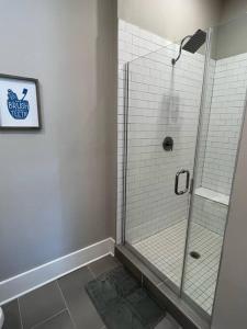 um chuveiro com uma porta de vidro na casa de banho em Modern 1BD Studio Apt in Plaza Midwood with Community Pool em Charlotte