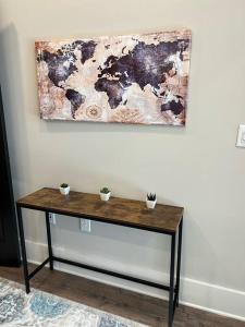 a wooden table with two potted plants on a wall at Modern 1BD Studio Apt in Plaza Midwood with Community Pool in Charlotte