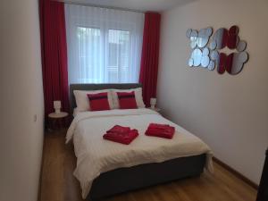 1 dormitorio con 1 cama grande con almohadas rojas en Apartament Owocowy, en Sandomierz