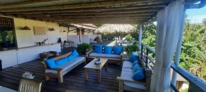 um pátio com almofadas azuis e sofás num deque em Guesthouse The 4 Fish em Manado