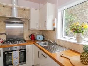 a kitchen with a sink and a window at Nathaniel's Cottage in Kirkcudbright