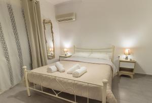 a bedroom with a bed with two pillows on it at Blue Era Apartments in Batsi