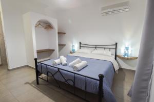 a bedroom with a bed with towels on it at Blue Era Apartments in Batsi