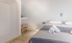 a white bedroom with two beds and a table at Blue Era Apartments in Batsi