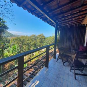 a balcony of a house with a view of the forest at Pousada do Holandes in Itaipuaçu