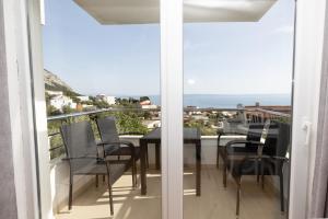 a balcony with a table and chairs and a view of the ocean at Maestral in Veliko Brdo