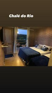 1 dormitorio con 2 camas y balcón en Chalé do Rio en Barreirinhas
