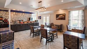 a restaurant with tables and chairs and a kitchen at Best Western Brentwood in Brentwood