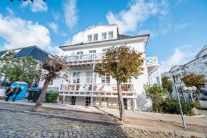 a white building on the side of a street at Ferienwohnung im Alten Postamt in Binz in Binz