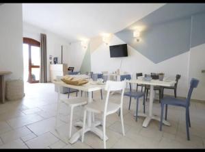 a dining room with a white table and blue chairs at B&B Torre Sibissi Bari in Triggiano