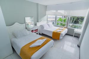 Кровать или кровати в номере ApartaSuites & Hotel Bogota Teusaquillo