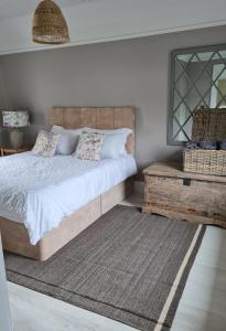 a bedroom with a large bed and a mirror at The Little White House in Tyrrellspass