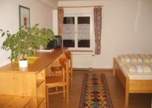 a living room with a desk and a table and a couch at Pension Sonne in Rickenbach