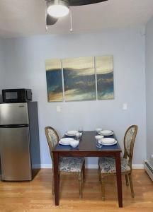 a dining room table with chairs and a refrigerator at Private Apt King Suite, L.I, NY-Hamptons to NYC in Coram