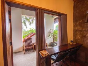 ein Esszimmer mit einem Holztisch und einem Balkon in der Unterkunft Cat Homestay in Hue