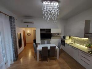 a kitchen and dining room with a table and a chandelier at Appartamento nel cuore di Porto Azzurro in Porto Azzurro