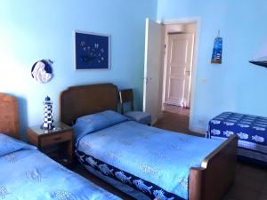 2 Betten in einem Zimmer mit blauen Wänden in der Unterkunft Bellissima turchese in Anzio