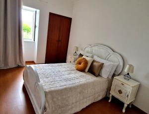 a bedroom with a large white bed and a window at Quintinha do Quintas in Valhascos +45 photos