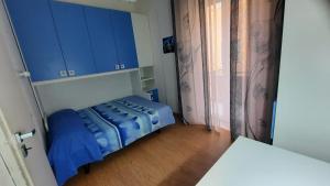um quarto com uma cama com armários azuis e uma janela em Appartamento nel cuore di Porto Azzurro em Porto Azzurro