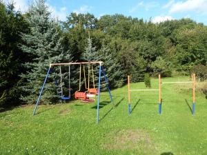 eine leere Schaukel auf einem Feld mit Bäumen in der Unterkunft Gästehaus am Schloßpark in Werben