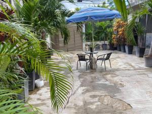 eine Terrasse mit Tisch und Stühlen und einem Sonnenschirm in der Unterkunft Casa Donde Entra la Luz y Vive la Naturaleza CCTV in Cozumel