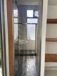 ein Badezimmer mit einem Waschbecken und einer Glastür in der Unterkunft Casa Donde Entra la Luz y Vive la Naturaleza CCTV in Cozumel