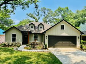 a house with a garage at The Benjamin I - 2022 Built Luxury Retreat with Backyard Paradise with Hot Tub Outdoor Movie Screen Dock & Boat Rental in Gun Barrel City
